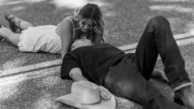 bride and groom laying on road