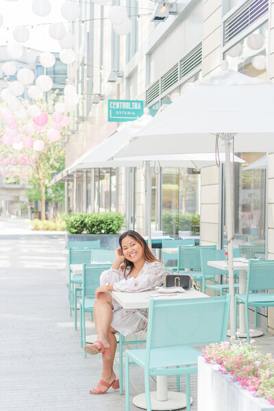 girl sitting on a teal chair during Washington, DC senior pictures