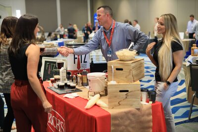 man shaking hands at a booth at a corporate event