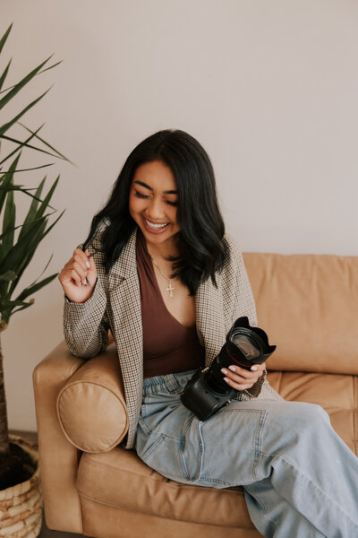 woman smiling down while holding a camera