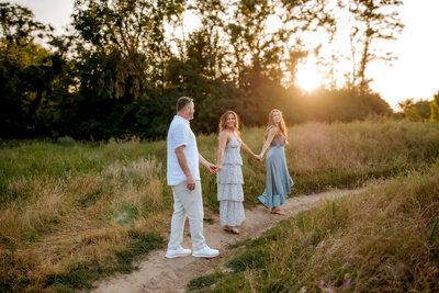 family of 6 standing posed together and looking at eachother and smiling  for their family photo  in St. Louis, MO.