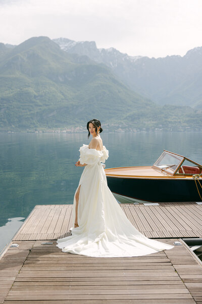a bride posing on a dock in her wedding dress
