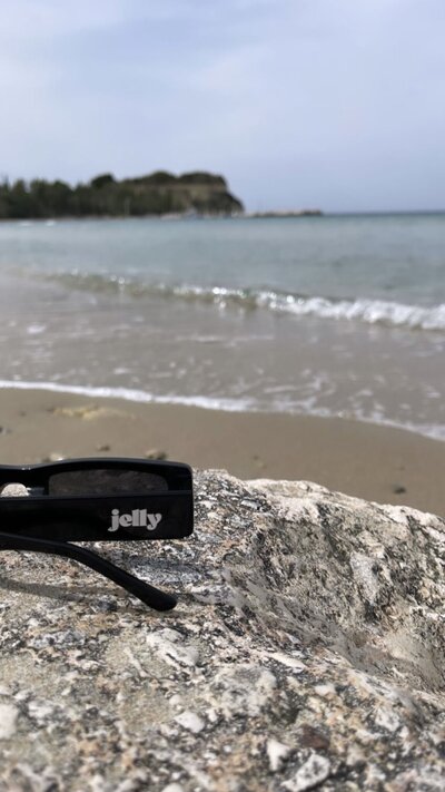 Jelly branded sunglasses on a rock