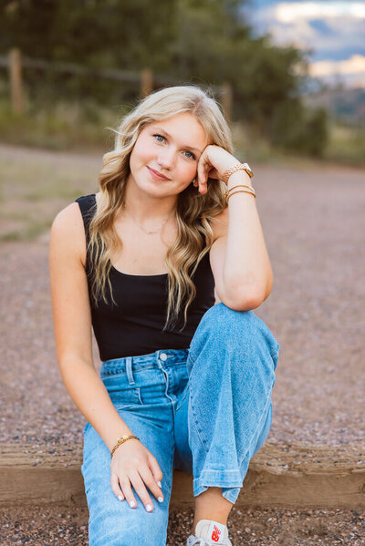 Girl in black tank and blue jeans poses for camera at South Valley Park in Colorado.
