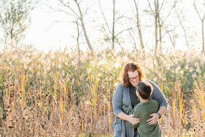 redheaded mother hugging her young son in a meadow; photo by Chicago Family Photographer Kristen Hazelton