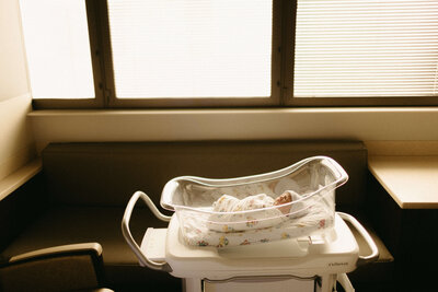 Close-up of newborn wrapped in white blanket on hospital bed in Nashville.