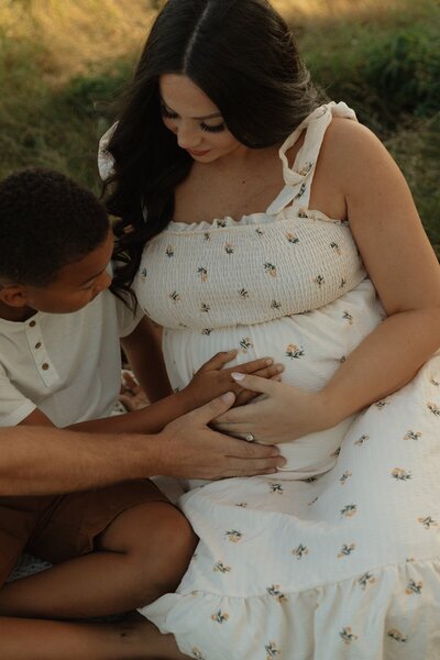 son feeling baby kick in moms belly during lifestyle photos in pei