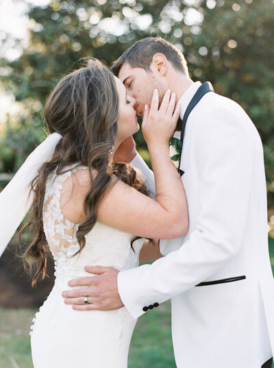 A portrait of a bride and groom kissing after their wedding ceremony