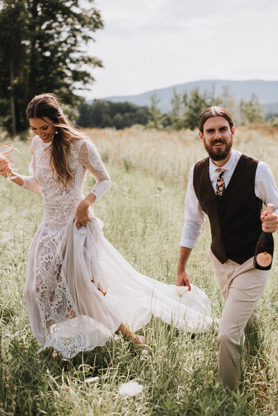 A well-dressed mountain wedding couple enjoy champagne in a field of wildflowers