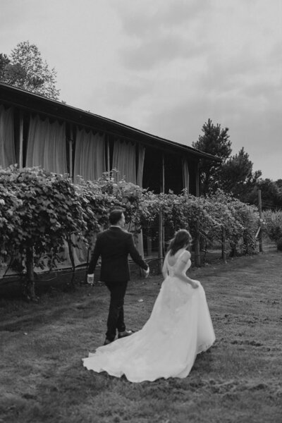 A bride and groom walking in the distance at Black Sheep Shelter, nestled in South Haven, Michigan.