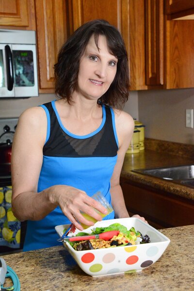 Penny in her kitchen preparing a salad