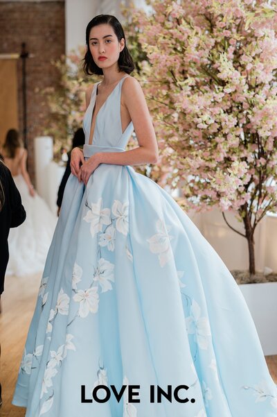 Model poses wearing a trending 2023 blue bridal gown