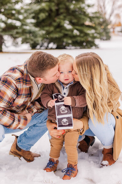 Family of 3 posing together showcasing a new baby for their family photos at the Jacoby Golf Course in Laramie, Wyoming.