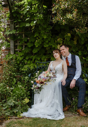 Bride and groom sharing romantic moment in garden