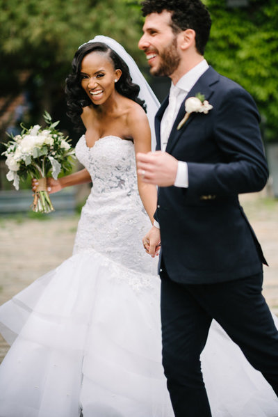 bride and groom run in happiness at their wedding at the foundry in LIC queens