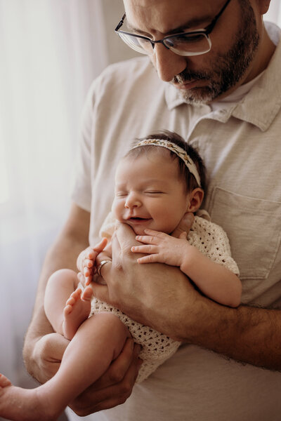 baby girl wrapped in a knit blanket wearing a dried flower crown.