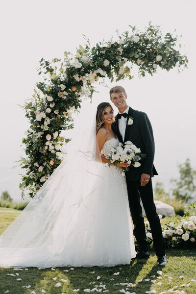 Couple by their ceremony floral arch