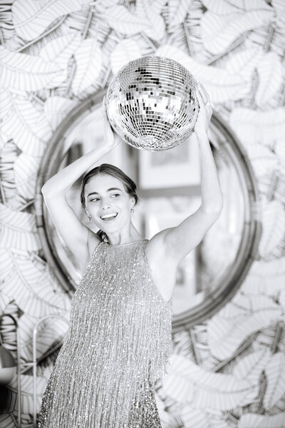 black and white photo of girl holding disco ball