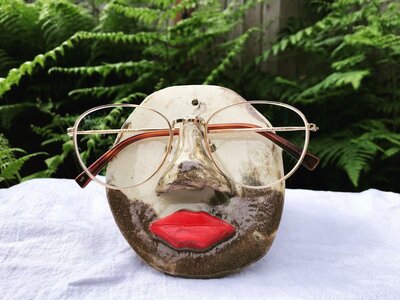 Handmade pottery, face shaped with nose to hold glasses and bright red lips 