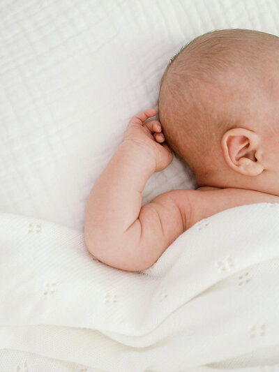 A close-up of a baby's arm and head during a Richmond newborn photography session by Katie Stansfield Photography.