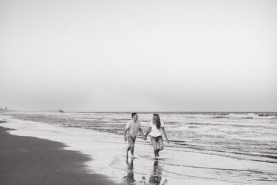 Couple running along the beach during sunset in Charleston, South Carolina