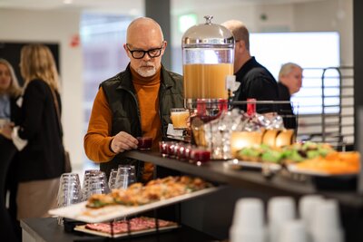 glada personer iklädda arbetskläder tittar på tapeter och golvprver