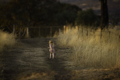 girl-running-down-a-path-at-sunset-having-time-of-her-life
