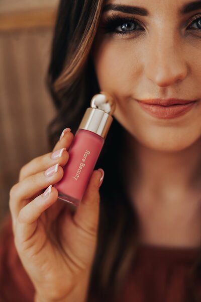 Detail photo of Caitlin holding a lip color product