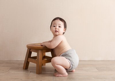 adorable toddler in squatting position. chubby cheeks and thick legs. showing how precious and tender this age is.