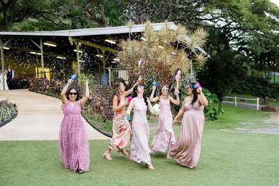 A wedding party walking into a reception while holding bubble makers 