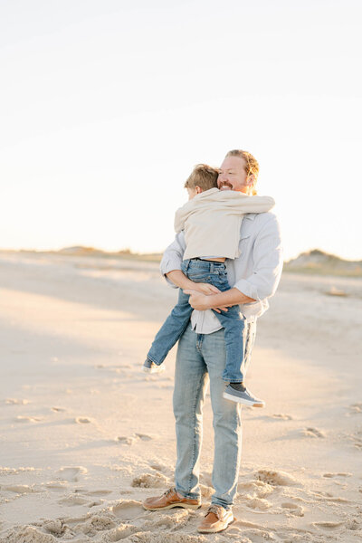 Cute family with three boys plays in a field during the fall