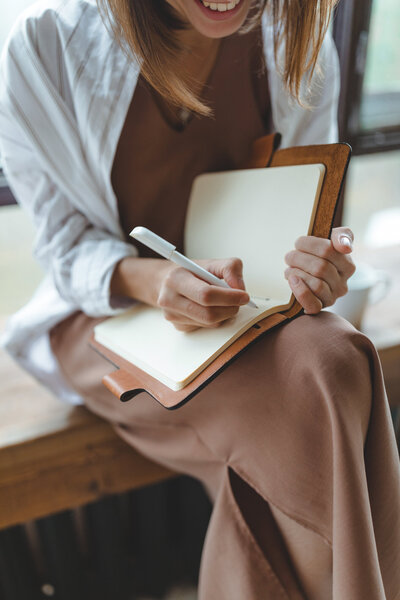 A young female in a white dress shirt staring off. Showing that not everyone knows that there are specific therapies for women. With support of a therapist for women you can gain confidence & build your self-esteem.
