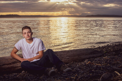 high school senior poses at west seattle beach for yearbook graduation photo