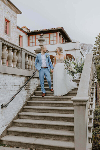 Bride and Groom walking down the steps at The Villa Terrace in Milwaukee, Bouquet created by Remington's floral in East Troy by wedding planners in wisconsin.