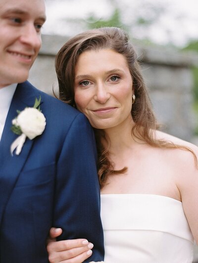 An asheville wedding photographer captures a close up of a bride resting on her groom's shoulder
