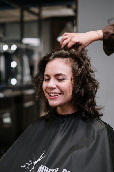 Sharper Edges Salon photograph of woman getting curly cut