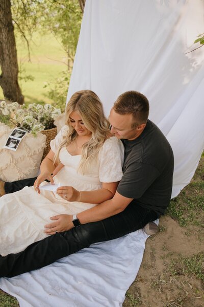 Gender reveal photo session with white sheet