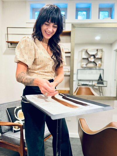Eugene salon owner puts different hair extensions on display, representing hair extensions for various hair colors and textures.