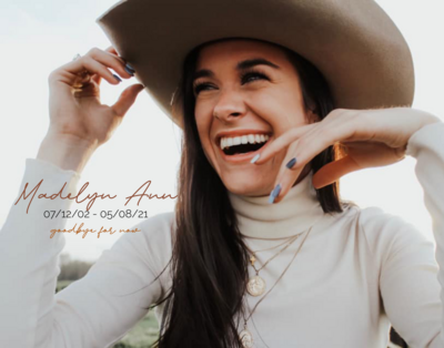dark haired girl smiling wearing a cowboy hat 