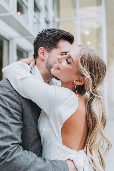 groom holding bride's veil