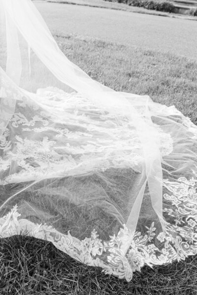 Elegant black and white image showcasing the bride gracefully holding a stunning wedding bouquet