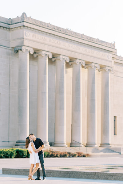 married couple dressed up and sitting on stairs in downtown Kansas City holding their small dog