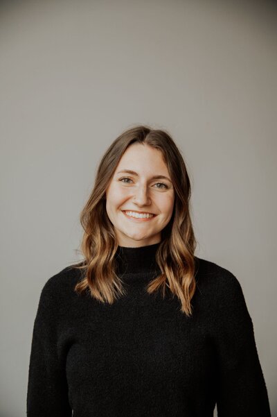 Kira Clark smiling in black sweater