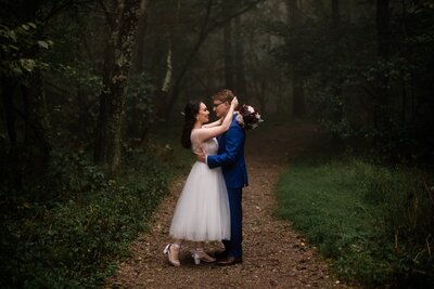 A couple snuggles in foggy woods after their Shenandoah National Park elopement