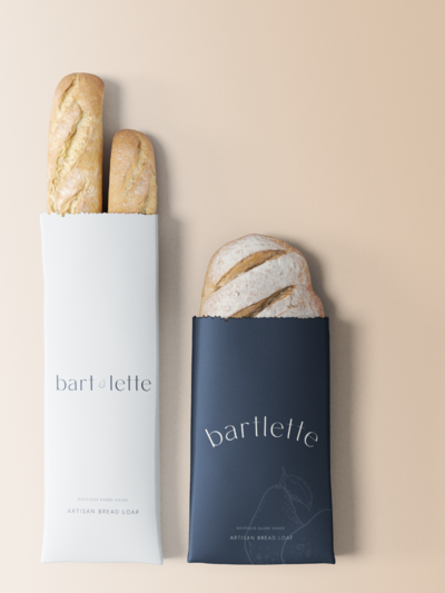 Two loaves of bread in branded paper packaging sleevesHome page of a website for an interior design e-commerce store with a dark moody background