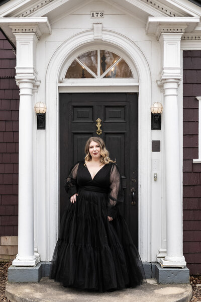Ashleigh Henry, speaker, writer, life coach, is in a black ball gown dress, in Asheville, North Carolina, showing the essence of embodied, inhabited living as a high-functioning, multi-faceted female founder and entrepreneur.