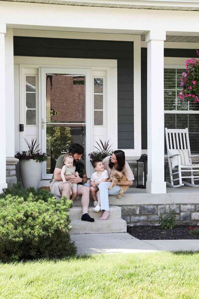 A Unica Formo family enjoys quality time together on their cozy porch, surrounded by a warm and inviting home atmosphere.