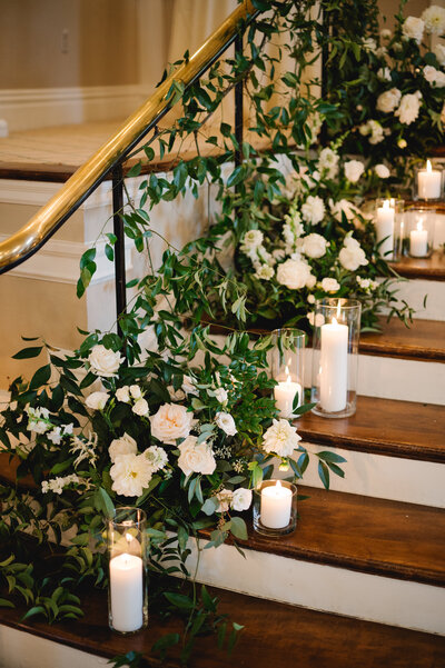 Lush floral arrangement with hydrangeas, roses, and greenery as a wedding reception table centerpiece by Leigh Florist, adding timeless elegance to the decor