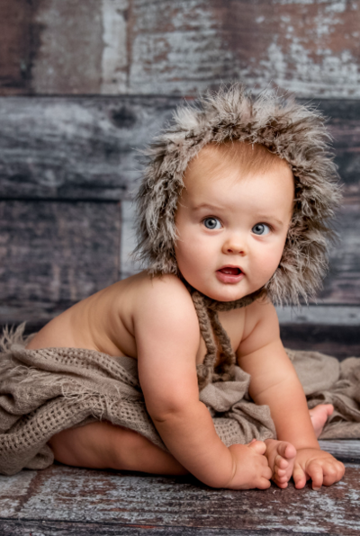 Baby in St Louis posing with neutral wooden tones