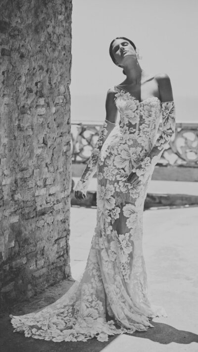 black and white image bride wearing satin wedding dress with high slit
